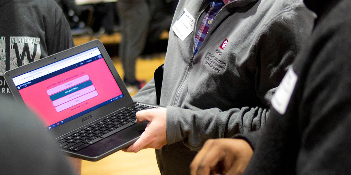 Student showing a trivia app on the laptop